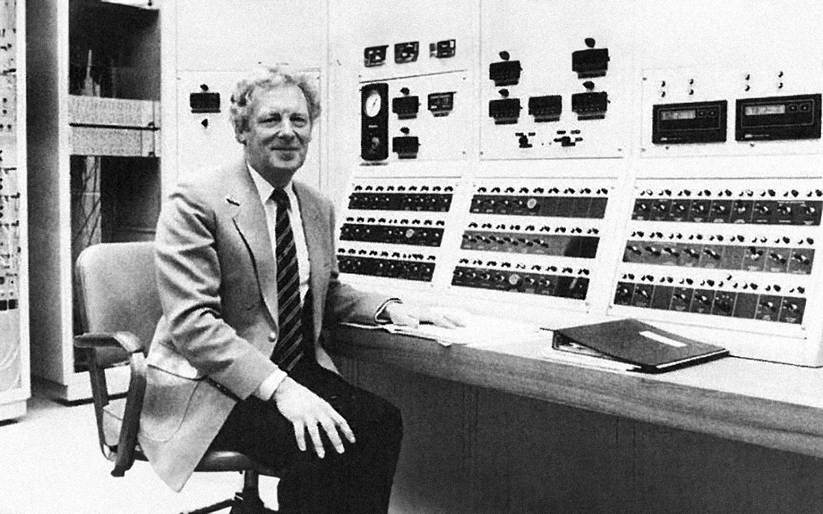 black and white image of person sitting in front of control board